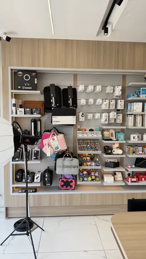 Prateleiras da IC Store com capas, bolsas, carregadores e cabos organizados